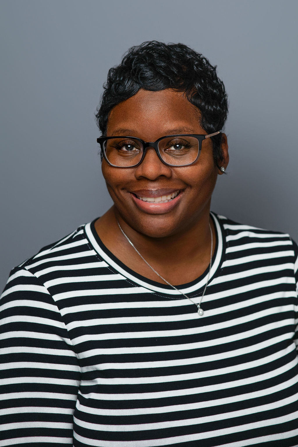 Smiling woman with glasses and striped shirt