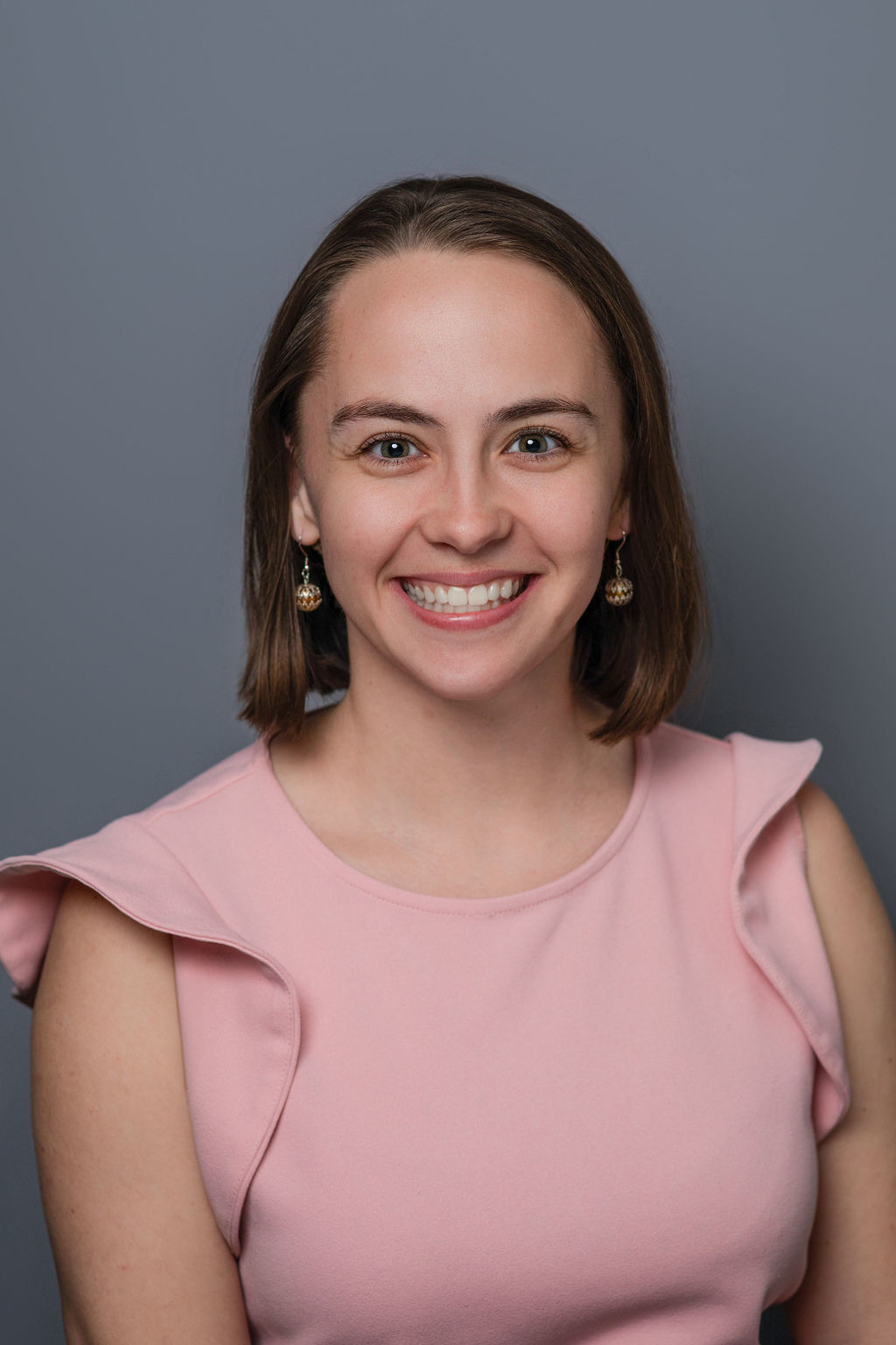 Smiling woman in pink blouse, studio portrait