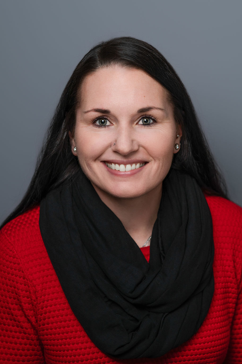 Smiling woman in red sweater and black scarf