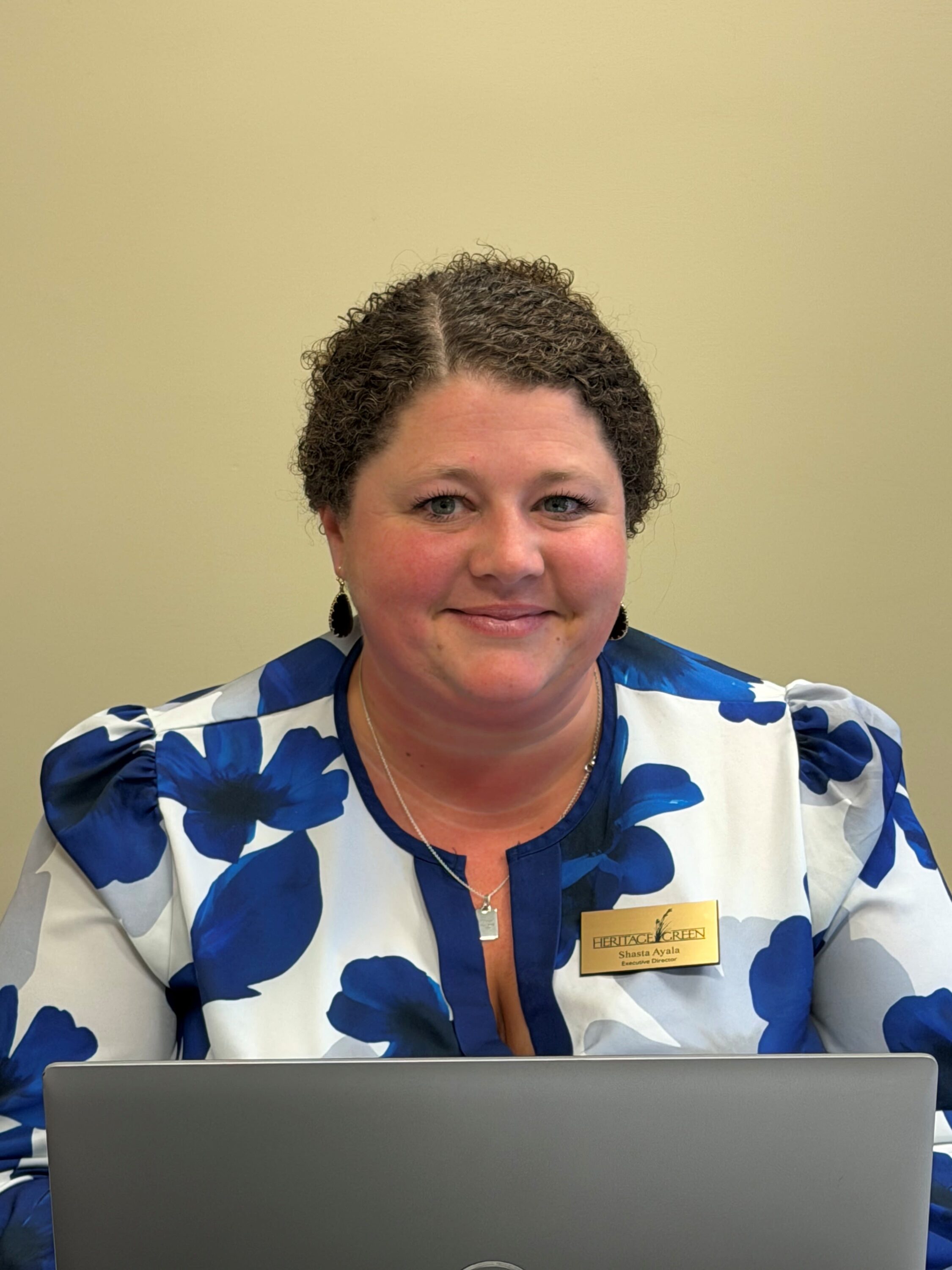 Woman with laptop wearing blue floral blouse